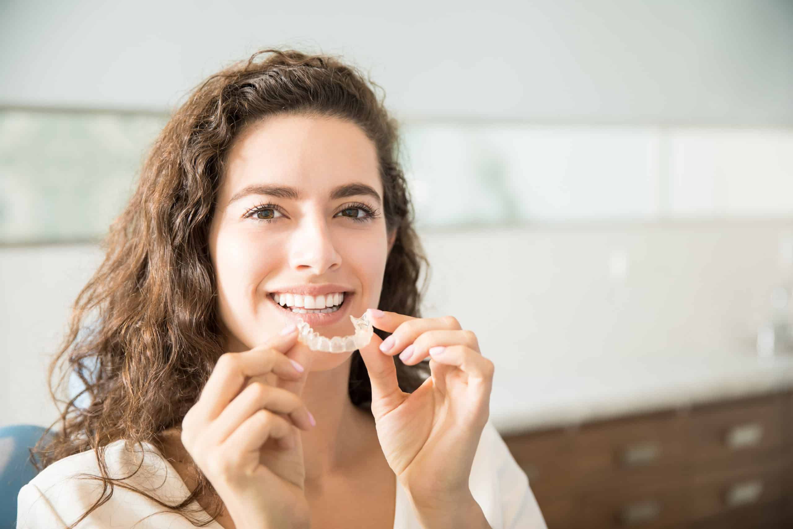 Diş kliniğinde ortodontik plakları tutan hasta portresi